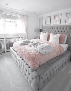 a large bed with pink and grey blankets on it