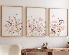 three paintings on the wall above a desk