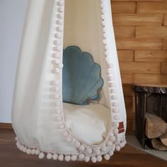 a white chair with pom poms hanging from it's sides