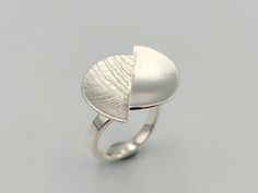 "This statement ring showcases two beautiful half moons and is totally handmade of 925 silver. One half moon has a crossed lines pattern and the other matte finish in contrast. This piece of jewellery is adjustable to any finger size. DETAILS Materials ⁃ sterling silver Length ⁃ 2.4cm / 0.94in  Width ⁃ 2.0cm / 0.79in  Weight ⁃ 6.57g  Adjustable size ✈️ SHIPPING & DELIVERY Fast Shipping Worldwide by DHL Express  Tracked, Safe, Secure Europe ⁃ Arrives in 1 - 2 working days USA ⁃ Arrives in 3 - 4 w Modern Sterling Silver Moon Jewelry, Handmade Sterling Silver Minimalist Midi Rings, Minimalist Silver Moon-shaped Midi Rings, Modern Sterling Silver Moon-shaped Jewelry, Modern Irregular Metal Ring Jewelry, Half Moon Ring, Lunar Jewelry, Half Moons, Ring Everyday