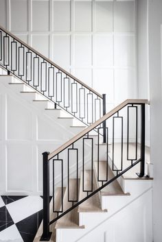 a black and white tiled floor next to a stair case