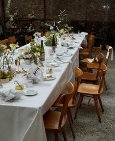 a long table is set with white linens and flowers