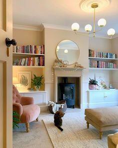 a living room filled with furniture and a cat laying on the floor next to a fire place