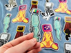 a person is holding up some stickers on a t - shirt that has many different designs