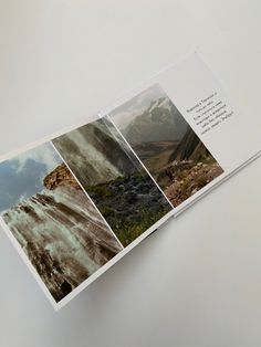 an open book with pictures of mountains and water in it's pages, on a white surface