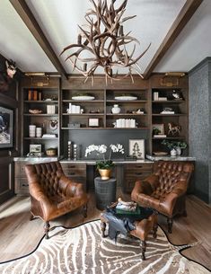 a living room filled with furniture and a large deer antler head hanging from the ceiling