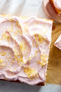 a piece of cake with pink frosting and lemons on it