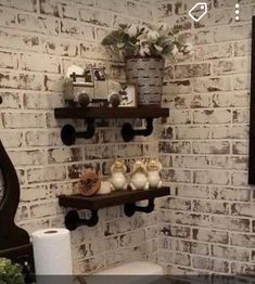 a bathroom with white brick walls and shelves on the wall, along with a toilet