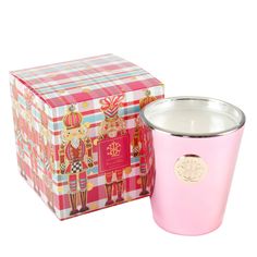 a pink candle sitting next to a box on top of a white surface with an image of a nutcracker