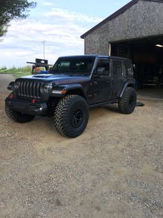 a black jeep parked in front of a garage