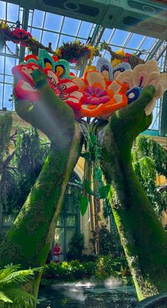 the inside of a building with plants and flowers on display