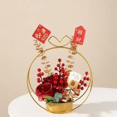 a vase filled with red flowers on top of a white table next to a sign