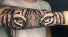 a man's arm with a tiger tattoo on it, and the eyes are open