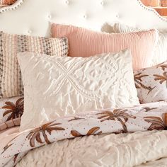 a white headboard and pillows in a bedroom with brick wall behind it at the foot of an upholstered bed