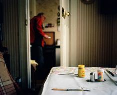 a person standing in the kitchen behind a table with food and utensils on it