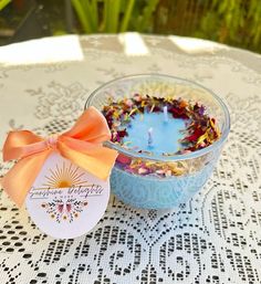 a small glass bowl filled with flowers and a candle