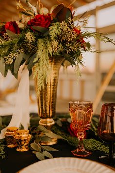 a table topped with a gold vase filled with flowers