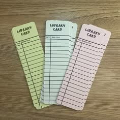 three library cards sitting on top of a wooden table