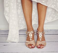 a woman's feet in high heeled sandals with jewels and pearls on them