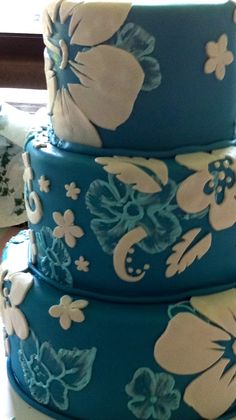 three tiered cake decorated with blue and white flowers