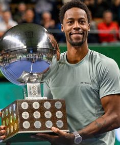 a male tennis player holding up a trophy