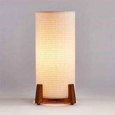 a lamp that is sitting on top of a wooden stand with a white light in the middle