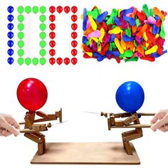 two hands are holding colorful balls and balancing them on a wooden board with pegs in the background