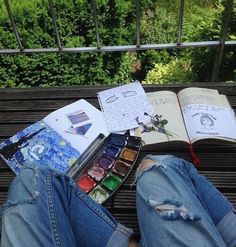 an open book sitting on top of a bench next to a person's feet