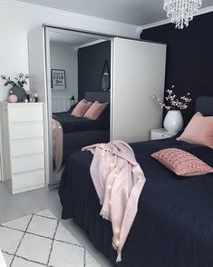 a black and white bedroom with pink accents