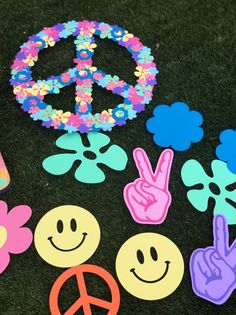 peace signs, flowers and smiley faces on the ground with confetti in the background