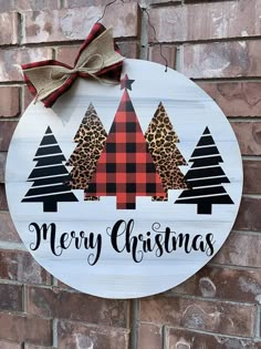 a merry christmas sign hanging on the side of a brick wall with trees and leopard print