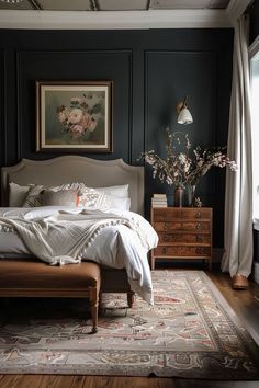 a bedroom with dark green walls and white linens on the bed, along with an antique rug