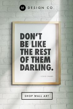 a white brick wall with a black and white poster on it that says don't be like the rest of them daring