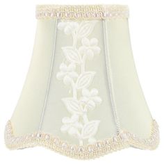 a white lamp shade with flowers on it's side and beaded trim around the bottom