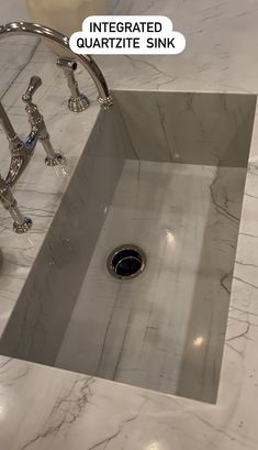 a sink that is in the middle of a marble counter top with an interesting faucet