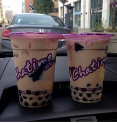 two drinks sitting on top of a car dashboard