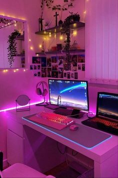 a computer desk with two computers on top of it in front of a purple light