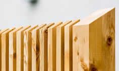 a close up of a wooden fence with a clock in the background