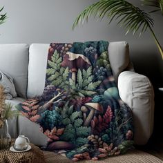 a living room with a couch, potted plants and a blanket on the floor