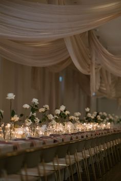 a long table with white flowers and candles