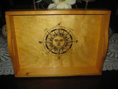 a wooden box with an image of the sun and moon on it's side