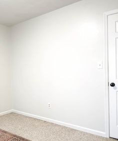 an empty room with white walls and carpet