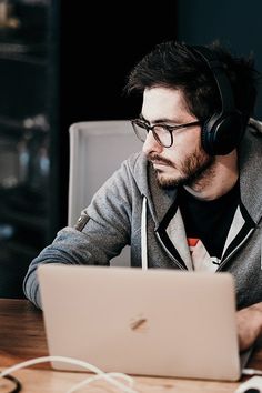 a man wearing headphones sitting in front of a laptop computer