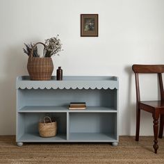 a blue shelf with some books on it and a basket in front of the shelf