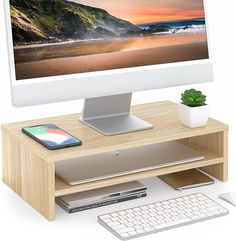 a computer monitor sitting on top of a wooden desk next to a keyboard and mouse