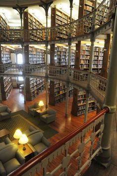 a large library with lots of bookshelves and couches on the second floor