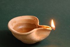 a small wooden bowl with a lit candle in it