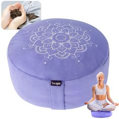 a woman sitting on top of a large purple cushion with an intricate flower design painted on it