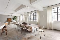 a large table and chairs are in the middle of an empty room with windows on both sides