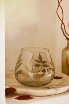 a glass with leaves on it sitting on a table